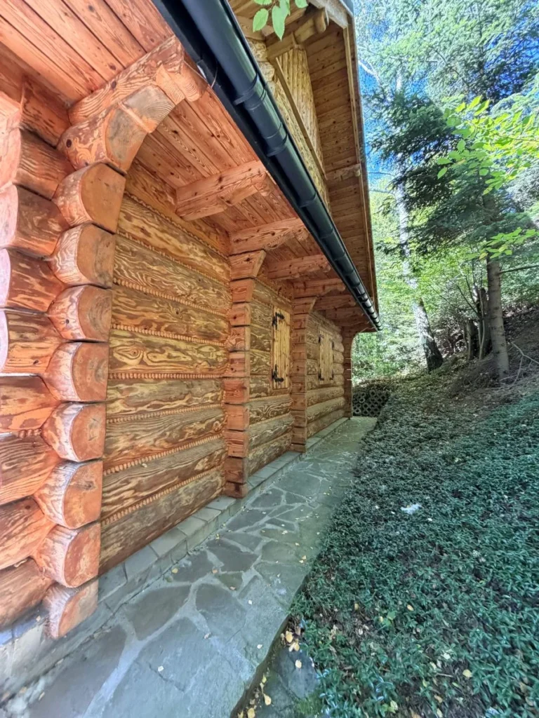 Drewniana elewacja domu oraz kamienna ścieżka przy budynku