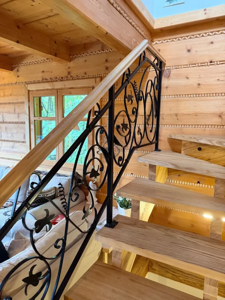 Drewniane schody z metalową balustradą we wnętrzu domu