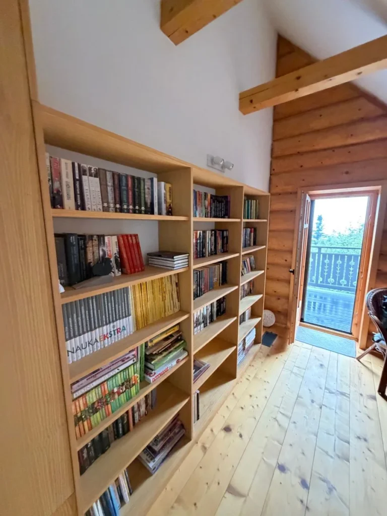 Korytarz z regałem na książki i wyjściem na balkon